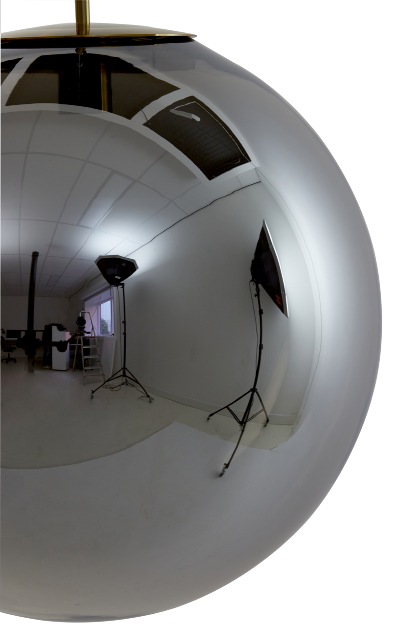 Nahaufnahme einer glänzenden, kugelförmigen Hängeleuchte mit reflektierender Oberfläche, die ein Fotostudio mit Beleuchtung und Kameraausrüstung zeigt.