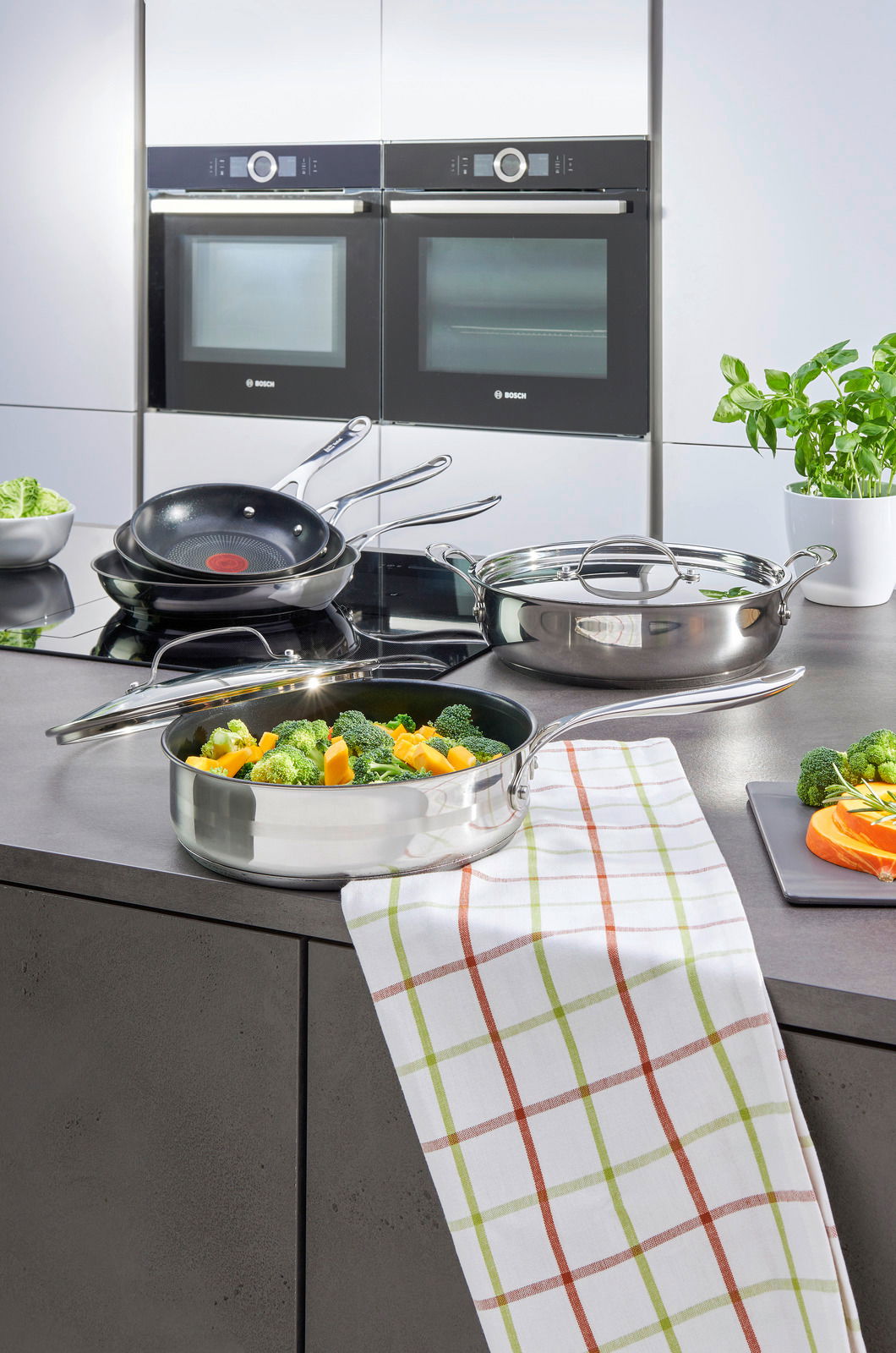 Bratpfanne Jamie Oliver Smart auf einem modernen Herd in einer Küche, gefüllt mit frischem Gemüse, aus der Vogelperspektive.