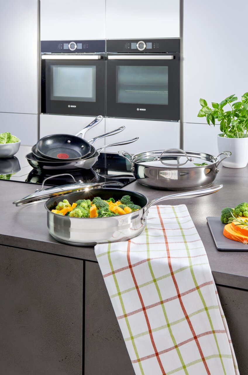 Jamie Oliver Smart-koekenpan op een modern fornuis in een keuken, gevuld met verse groenten, gezien vanuit vogelperspectief.