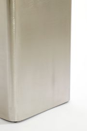 Nahaufnahme einer silbernen, rechteckigen Säule mit glatter Oberfläche, perspektivisch von der Seite aufgenommen.