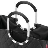 Nahaufnahme einer schwarzen Tasche mit Rautenmuster und zwei großen, ovalen Griffen in Schwarz und Weiß.