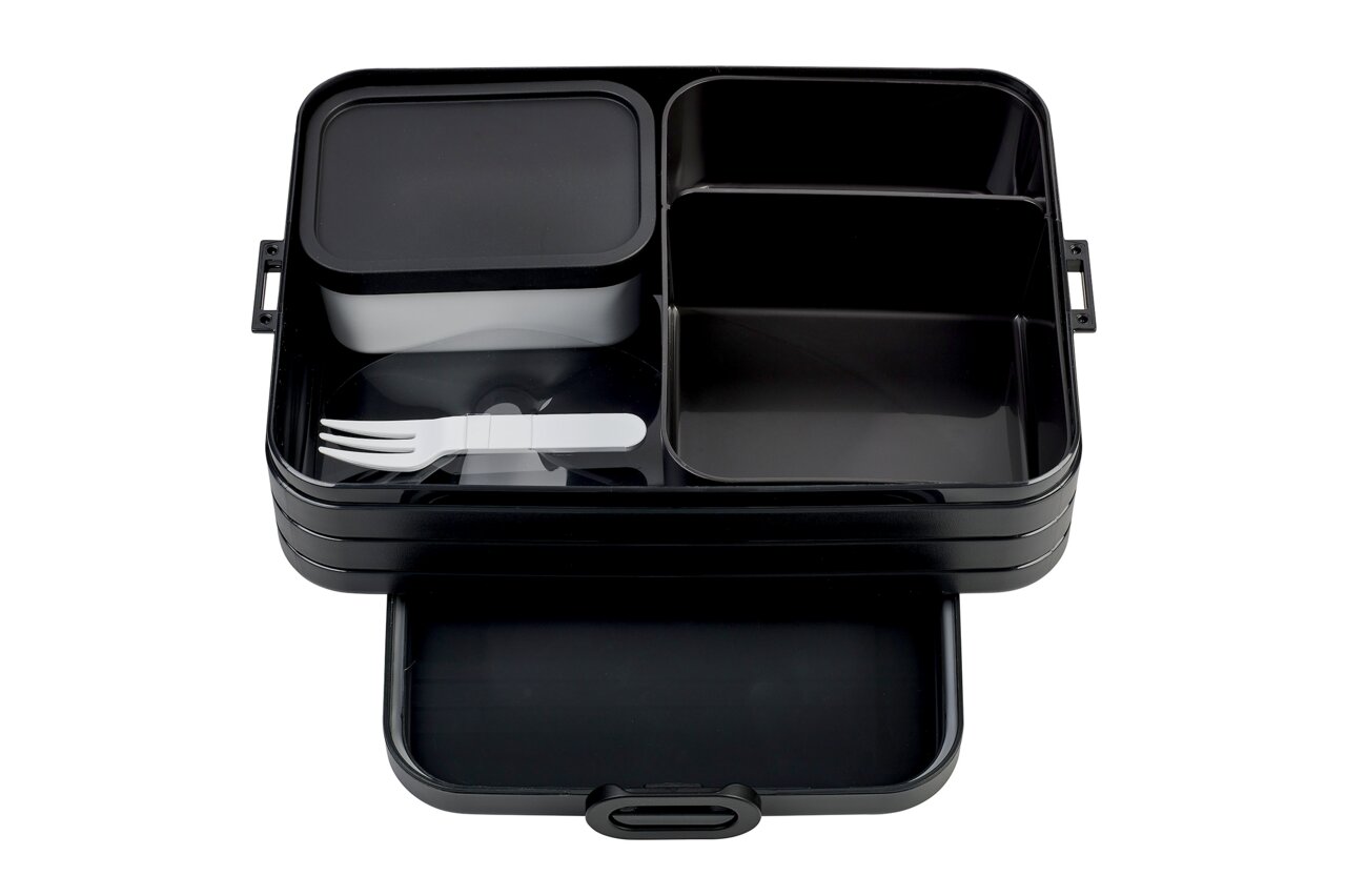 Zwarte bento-lunchbox met meerdere vakken en wit bestek, gefotografeerd vanuit vogelperspectief.
