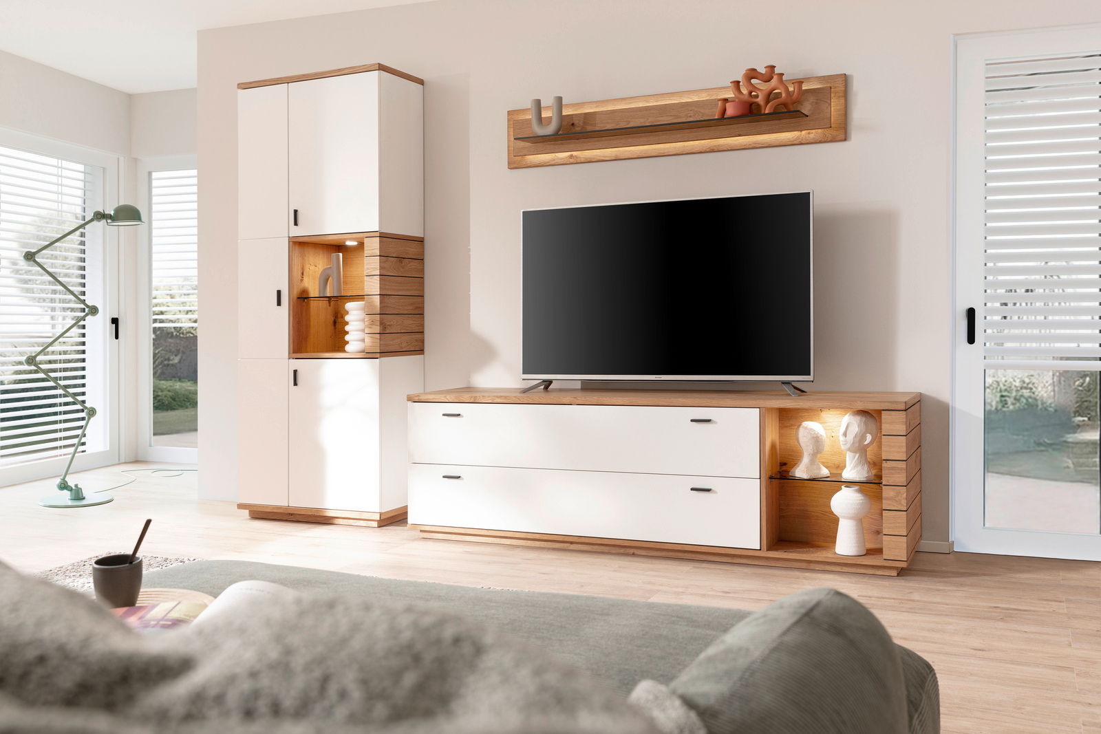 Modernes Highboard in einem Wohnzimmer, mit weißem und holzfarbenem Design, von vorne betrachtet.