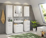 Moderner weißer Standschrank im Badezimmer, frontal betrachtet, umgeben von weiteren weißen Badmöbeln und Pflanzen.