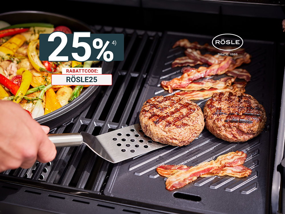 Burger-Patties und Speck auf Grill, daneben Pfanne mit Gemüse, Hand hält Grillspatel.