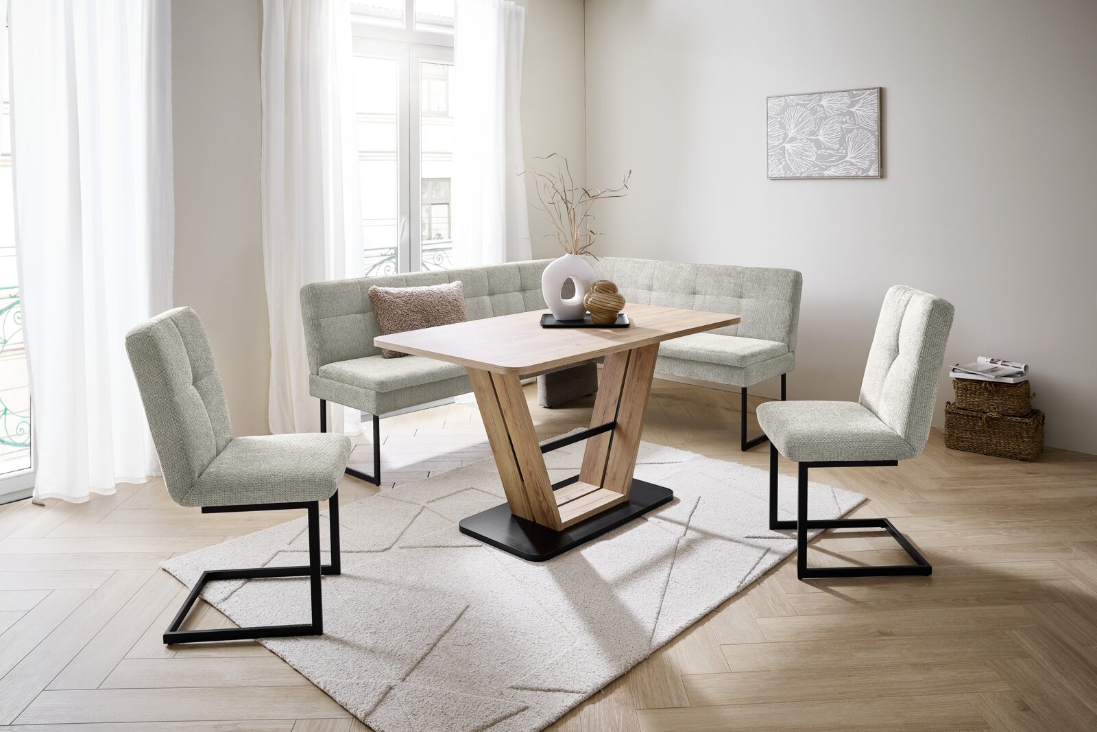 Novel Schommelstoel QUICK Moderne eethoek met hoekbank, houten tafel en gestoffeerde stoelen in een lichte ruimte, gezien vanuit de zijkant.