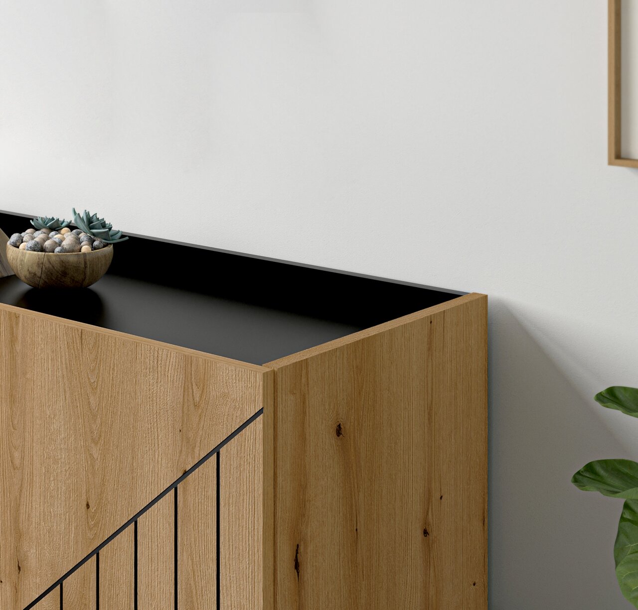 Holz-Sideboard mit schwarzer Oberseite, dekoriert mit einer Schale voller Steine und Pflanzen, aus seitlicher Perspektive.