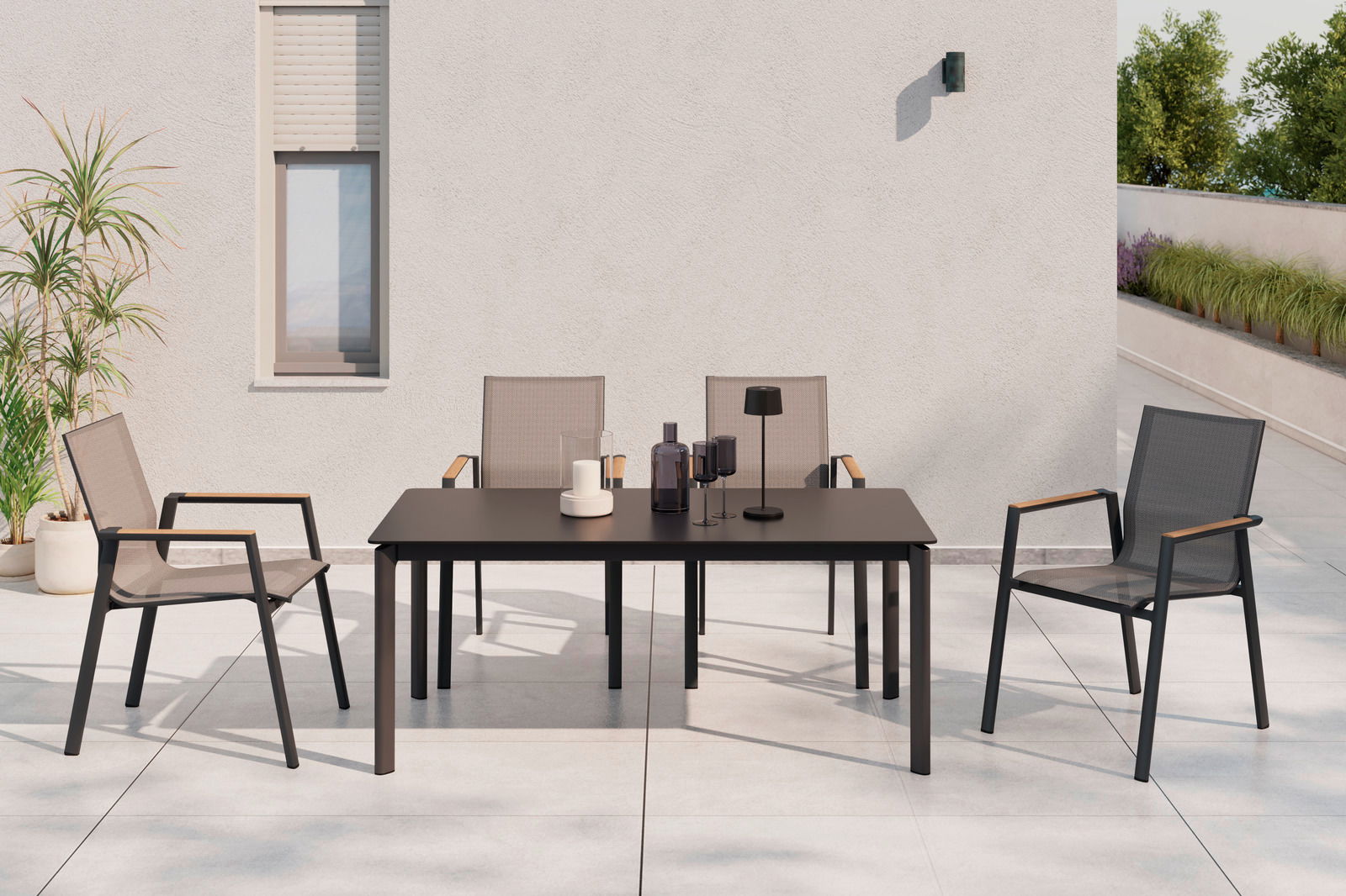 Moderner Stapelstuhl aus Metall und Textil mit Armlehnen, auf einer Terrasse neben einem Tisch, aus der Frontalperspektive.