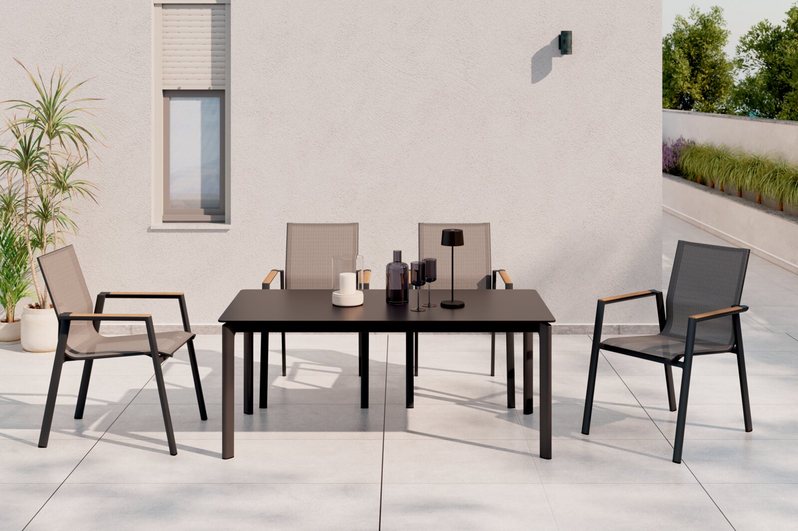 Moderner Stapelstuhl aus Metall und Textil mit Armlehnen, auf einer Terrasse neben einem Tisch, aus der Frontalperspektive.