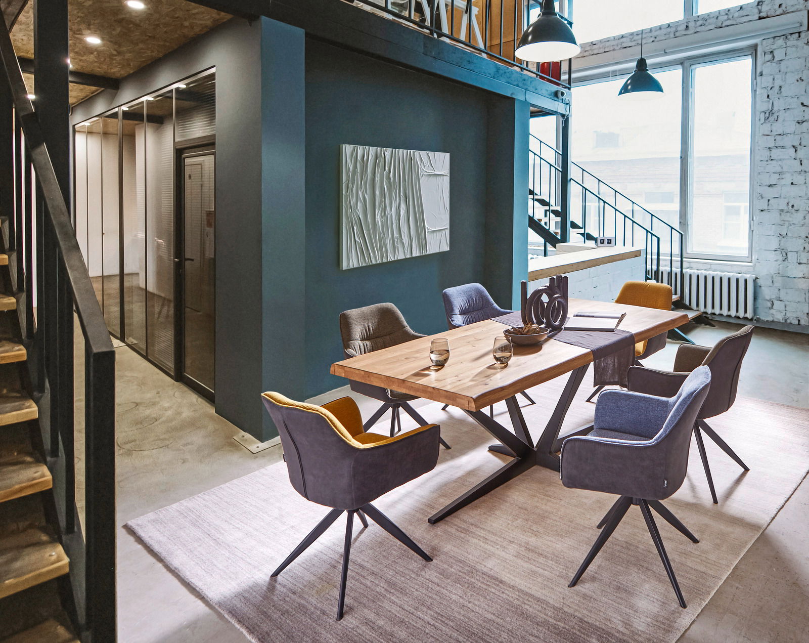 Moderner Essbereich mit einem großen Holztisch und sechs gepolsterten Sesseln in einem stilvollen Loft-Ambiente, seitliche Perspektive.