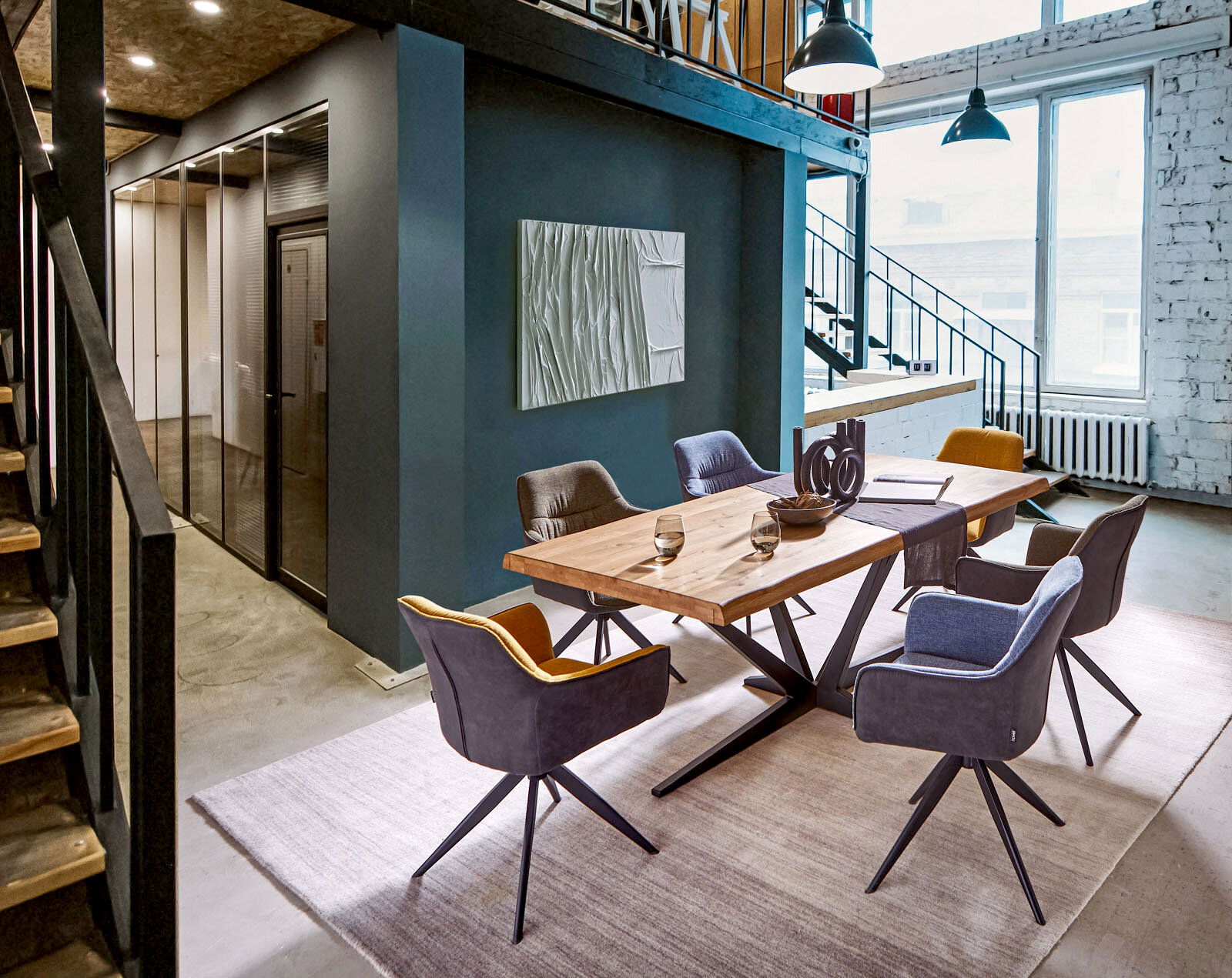 Moderner Essbereich mit einem großen Holztisch und sechs gepolsterten Sesseln in einem stilvollen Loft-Ambiente, seitliche Perspektive.