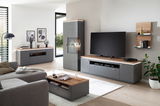 Moderne Wohnzimmermöbel in grauer und holzfarbener Optik, bestehend aus Sideboard, Wandkombination und Couchtisch, aus der Perspektive eines gemütlichen Wohnzimmers.