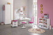 Moderne draaistoel voor jongeren met een roze zitting en een rugleuning met stippen, zijaanzicht in een stijlvol ingerichte kinderkamer.