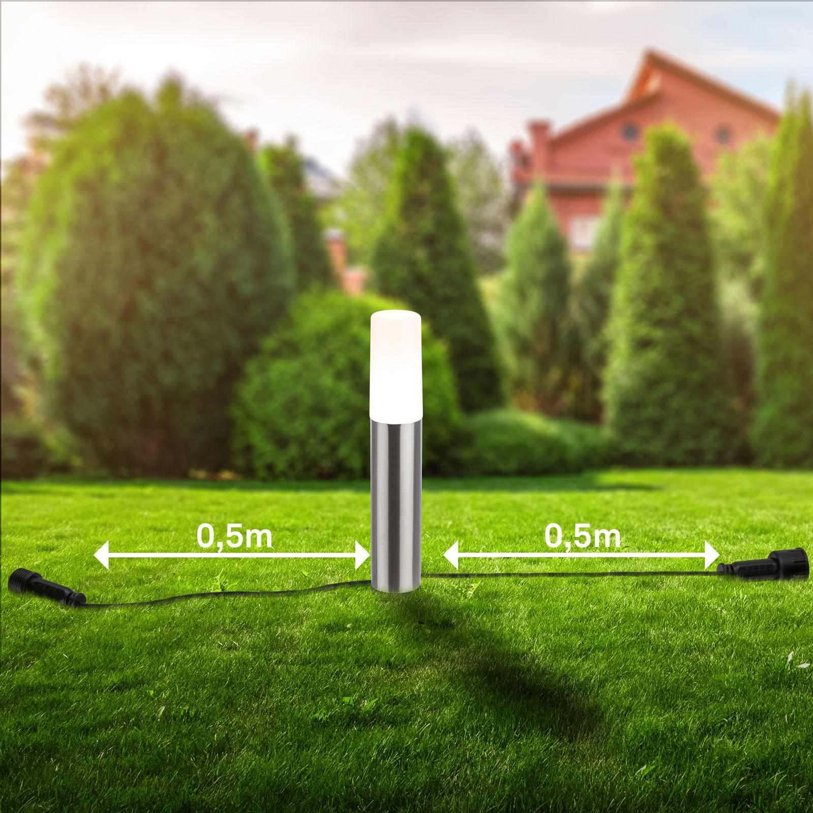 Bodenspieß mit Leuchte in einem Garten, frontal fotografiert, mit zwei Kabeln, die jeweils 0,5 m lang sind.
