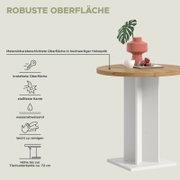 Runder Esstisch mit melaminharzbeschichteter Holzoptik-Tischplatte und weißem Säulenfuß, darauf Vase mit Blatt, Tasse und Macarons; Perspektive: schräg von vorn rechts mit Fokus auf Tischkante und Oberfläche
