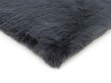 Grauer Fellteppich in Nahaufnahme, perspektivisch von der Seite fotografiert