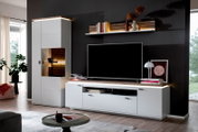 Moderne Wohnwand in Weiß mit Holzoptik-Akzenten, TV-Lowboard, Vitrinenschrank mit Beleuchtung und Wandregal mit LED-Licht, frontal aus leicht schräger Perspektive im Wohnzimmer fotografiert