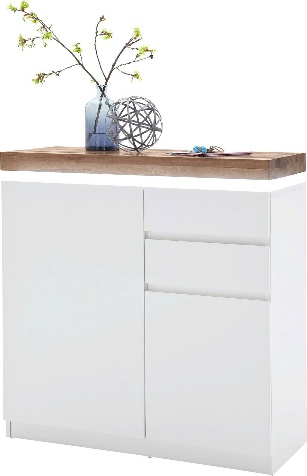 Moderner weißer Schuhschrank mit Holzplatte, dekoriert mit einer Vase und Zweigen, aus frontaler Perspektive.
