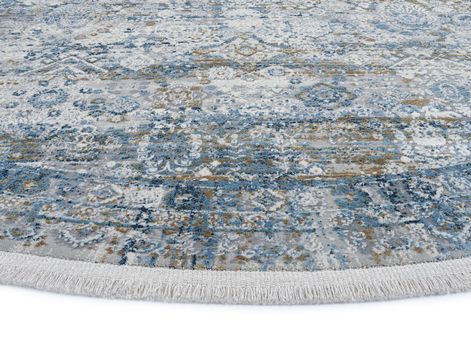 Runder Designer Teppich mit blau-grauem Muster und Fransen, Nahaufnahme der Textur und Farben.