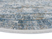 Runder Designer Teppich mit blau-grauem Muster und Fransen, Nahaufnahme der Textur und Farben.