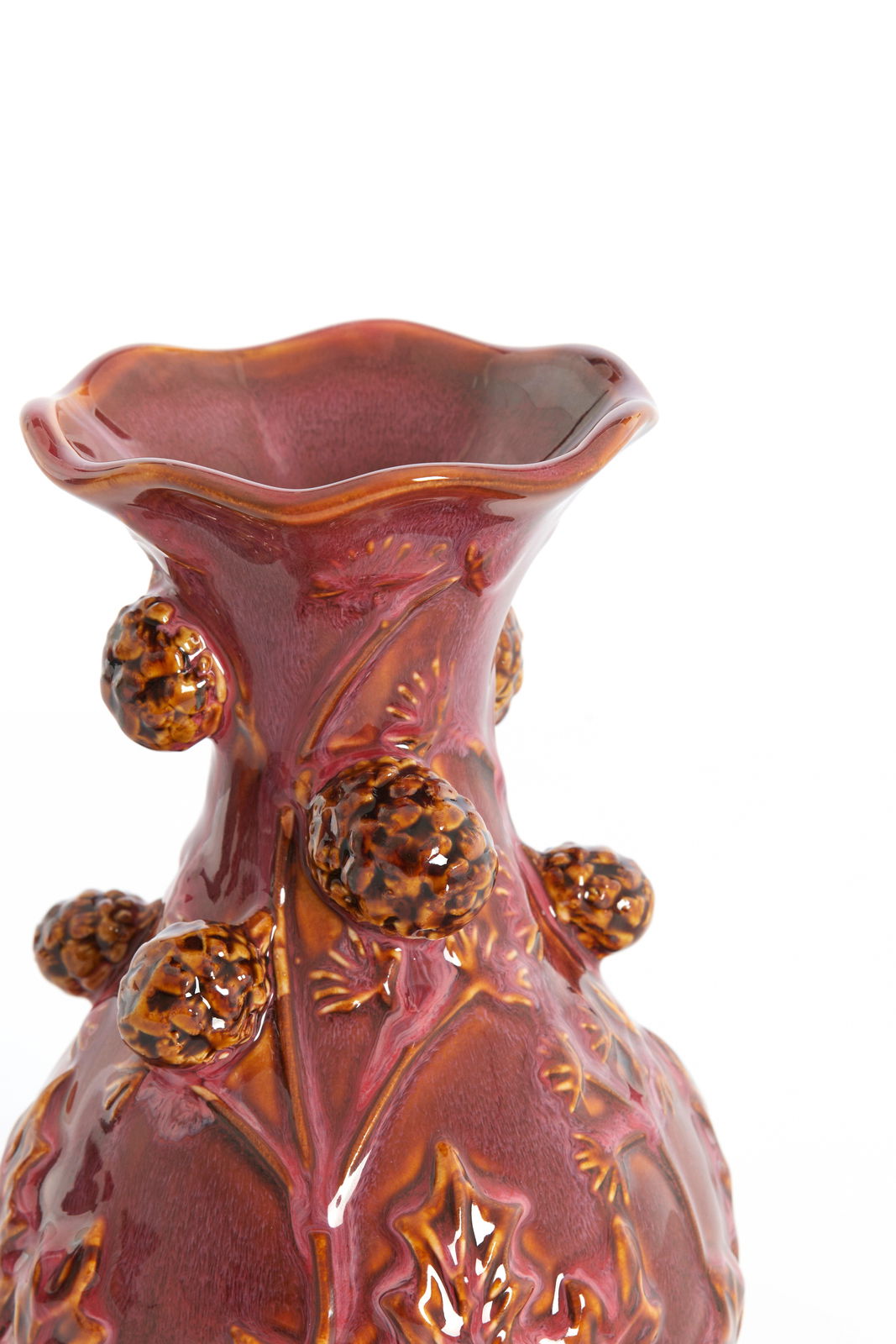 Nahaufnahme einer dekorativen Vase mit welligem Rand und erhabenen, blattähnlichen Verzierungen in warmen Rottönen.