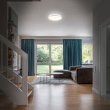 Moderne LED-Badleuchte an der Decke eines stilvollen Wohnzimmers, aus der Perspektive des Eingangsbereichs fotografiert.
