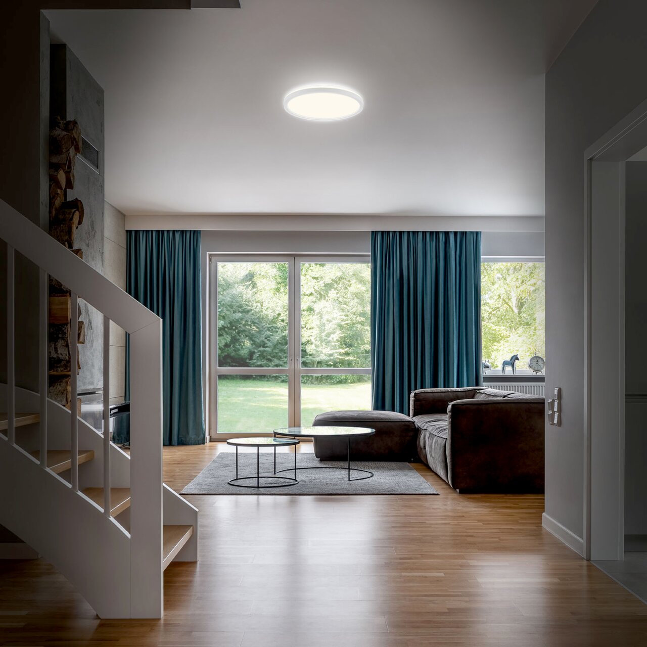 Moderne led-badkamerlamp aan het plafond van een stijlvolle woonkamer, gefotografeerd vanuit de hal.