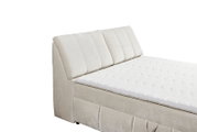 Beiges Boxspringbett mit gepolstertem Kopfteil, seitliche Perspektive