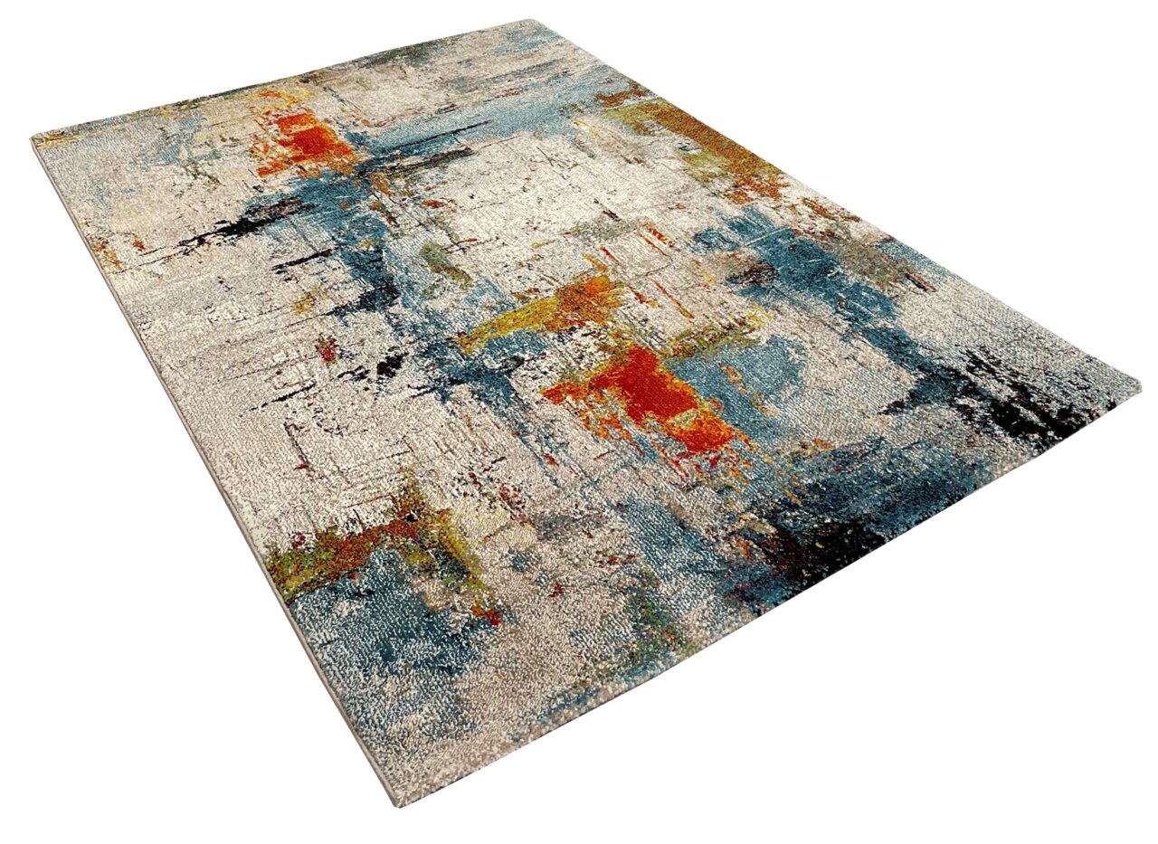 Merinos Webteppich BELIS Moderner Teppich mit abstraktem Design in Blau-, Rot- und Beigetönen, perspektivisch von der Seite fotografiert.