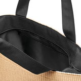 Nahaufnahme einer Shopper-Tasche aus Raffia in Schwarz mit Reißverschluss und schwarzen Griffen, von oben betrachtet.