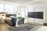 Moderner Schwebetürenschrank mit zwei Türen in einem stilvollen Schlafzimmer, seitliche Perspektive.