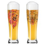 Zwei Weizenbiergläser mit Schaumkrone, eines mit einem bunten Löwenmotiv und das andere mit einem Tigerdesign, aus der Frontalperspektive.