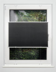 Schwarzes Plissee am Fenster, halb heruntergelassen, mit Blick auf einen Garten im Hintergrund.