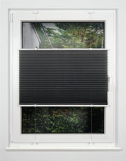 Schwarzes Plissee am Fenster, halb heruntergelassen, mit Blick auf einen Garten im Hintergrund.