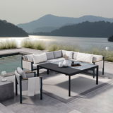 Moderne Lounge-Möbel auf einer Terrasse mit Seeblick, bestehend aus einem Ecksofa, einem Sessel und einem Gartentisch. Perspektive von schräg oben.