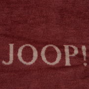 Nahaufnahme einer roten Decke mit dem weißen Schriftzug 'JOOP!'
