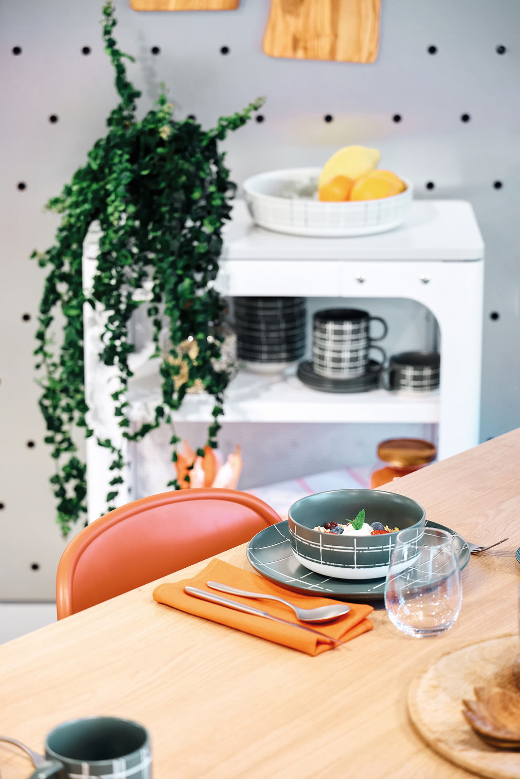 Müslischale 15 cm auf einem gedeckten Tisch, gefüllt mit Müsli und Früchten, in einer modernen Küchenszene, seitliche Perspektive