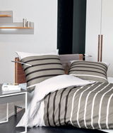 Bettwäsche-Set aus Mako-Satin in 135x200 cm mit grauen und weißen Streifen, auf einem modernen Bett in einem stilvollen Schlafzimmer präsentiert, seitliche Perspektive.