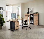 Moderner Büroraum mit Voleo E-Schreibtisch DETROIT in Holzoptik, Rollcontainer und ergonomischem Bürostuhl, seitliche Perspektive.