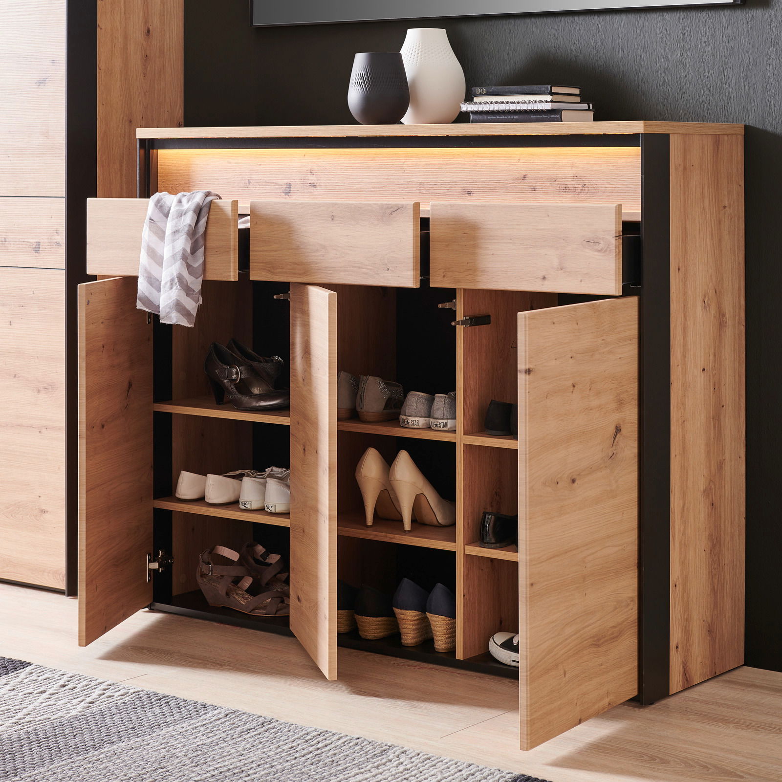 XL-Schuhschrank aus Holz mit offenen Türen und Schubladen, gefüllt mit verschiedenen Schuhen, aus einer frontalen Perspektive fotografiert.