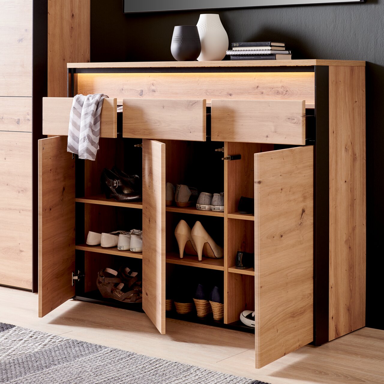 XL-schoenenkast van hout met open deuren en lades, gevuld met verschillende schoenen, gefotografeerd vanuit een vooraanzicht.