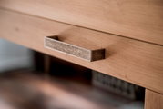 Nahaufnahme eines Holzschranks mit einem metallischen Griff, seitliche Perspektive
