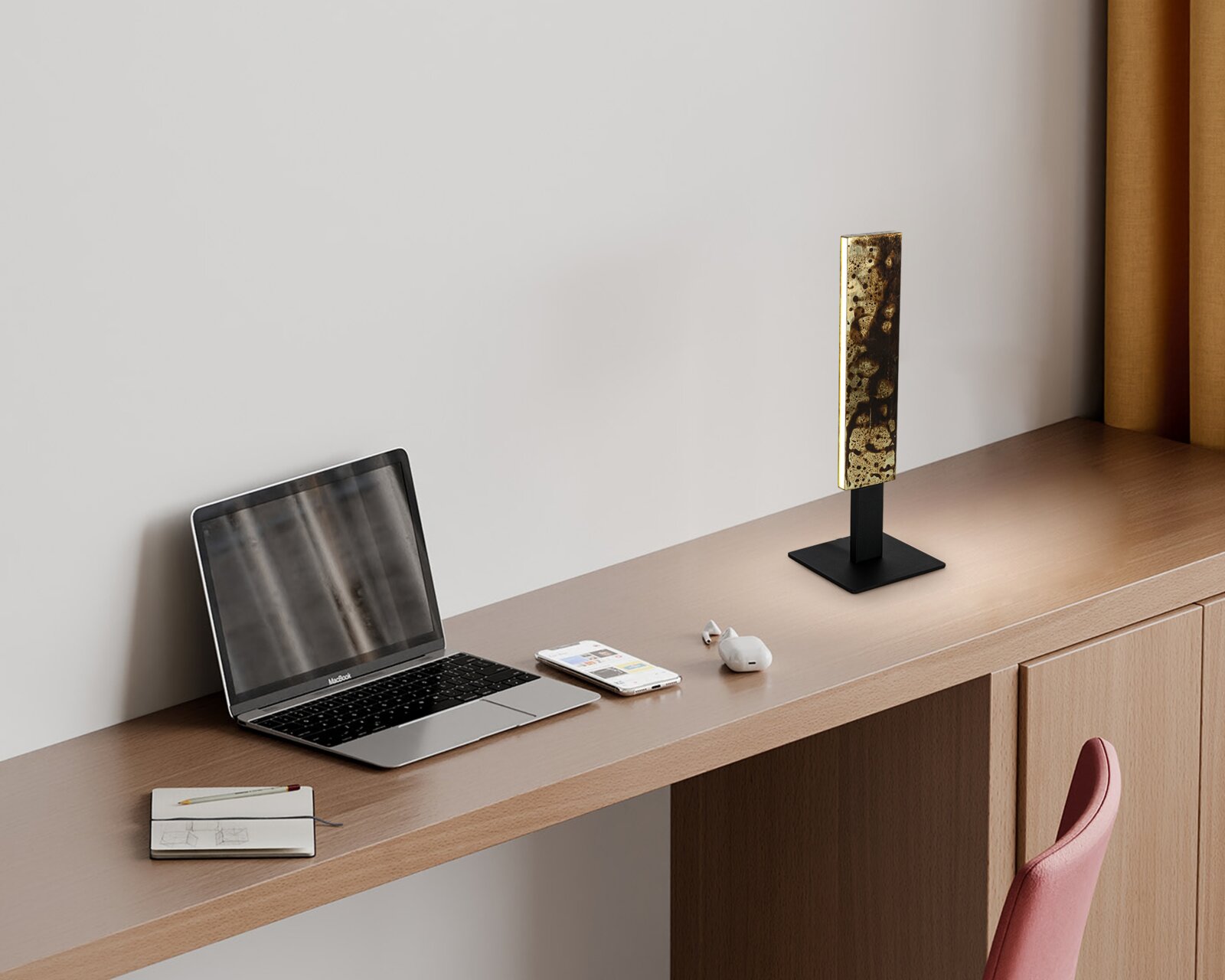 Moderne led-tafellamp met een rechthoekige, goudkleurige kap op een zwarte voet, zijaanzicht op een bureau naast een laptop.