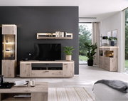 Modernes Wohnzimmer-Setup mit hellen Holz- und anthrazitfarbenen Möbeln: TV-Lowboard mit Fernseher, Wandregal, beleuchteter Vitrine und Sideboard, aufgenommen in frontaler Perspektive.