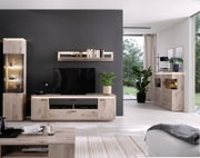 Moderne woonkamerinrichting met meubels in licht hout en antraciet: tv-kast met televisie, wandrek, verlichte vitrinekast en dressoir, gefotografeerd vanuit een vooraanzicht.