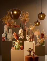 Hängeleuchte in einem stilvollen Raum mit herbstlicher Dekoration, aus der Perspektive von vorne betrachtet.