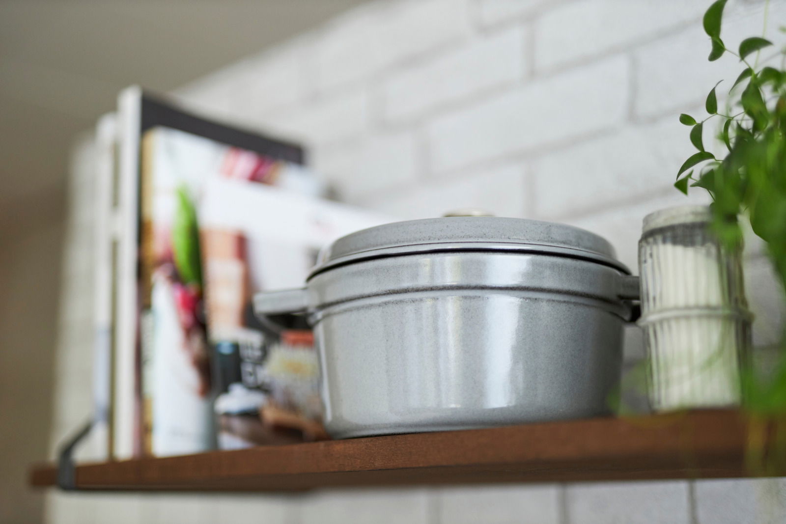 Grauer runder Bräter Cocotte 24cm auf einem Regal, seitliche Perspektive