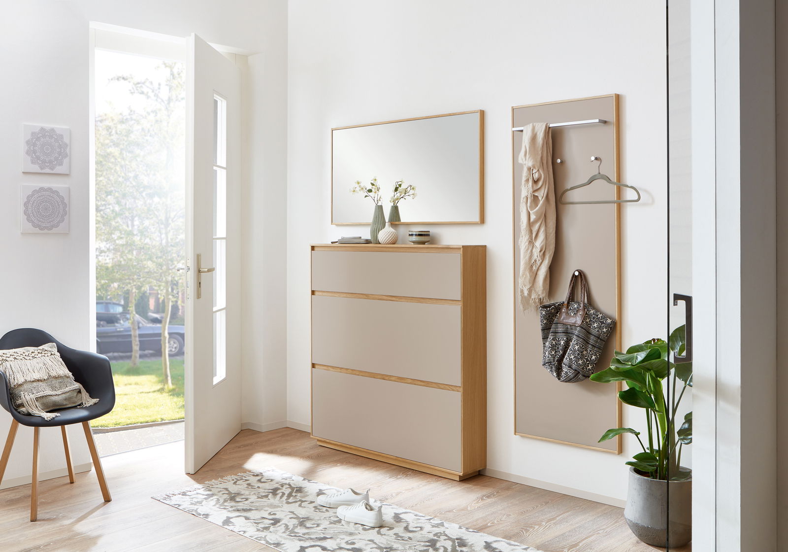 Moderne Garderobeneinrichtung mit Schuhschrank, Spiegel und Garderobenpaneel in einem hellen Flur. Perspektive von vorne.