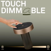Hand dimmt eine Solar-Gartenleuchte mit Touch-Dimmfunktion auf dem runden Bedienfeld; Nahaufnahme aus leicht schräger Draufsicht