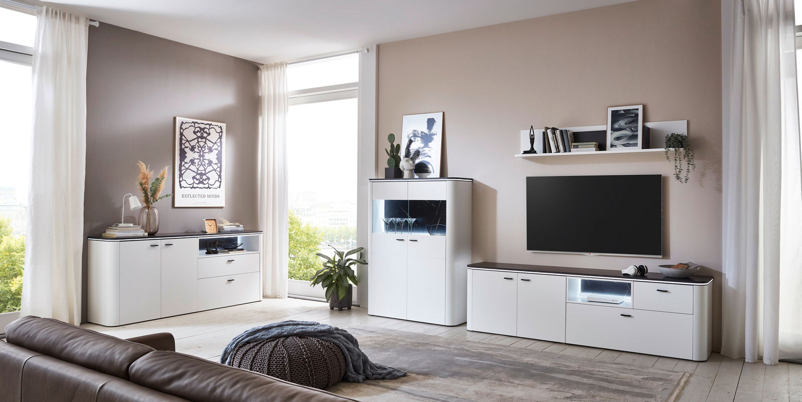 Moderne Wohnzimmer-Wandkombination in Weiß mit Schränken, Regalen und TV-Bereich, seitliche Perspektive
